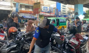 Seorang juru parkir yang sedang bertugas di Kiaracondong, Kota Bandung, Sabtu 29 November 2025 (Foto: AYOBANDUNG.ID/Asti Alya Anggraini)