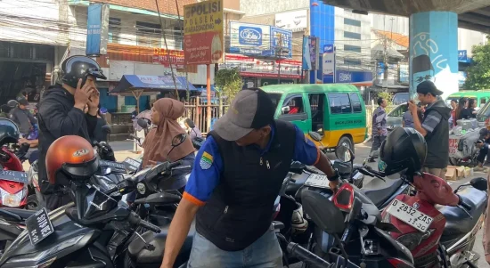 Seorang juru parkir yang sedang bertugas di Kiaracondong, Kota Bandung, Sabtu 29 November 2025 (Foto: AYOBANDUNG.ID/Asti Alya Anggraini)