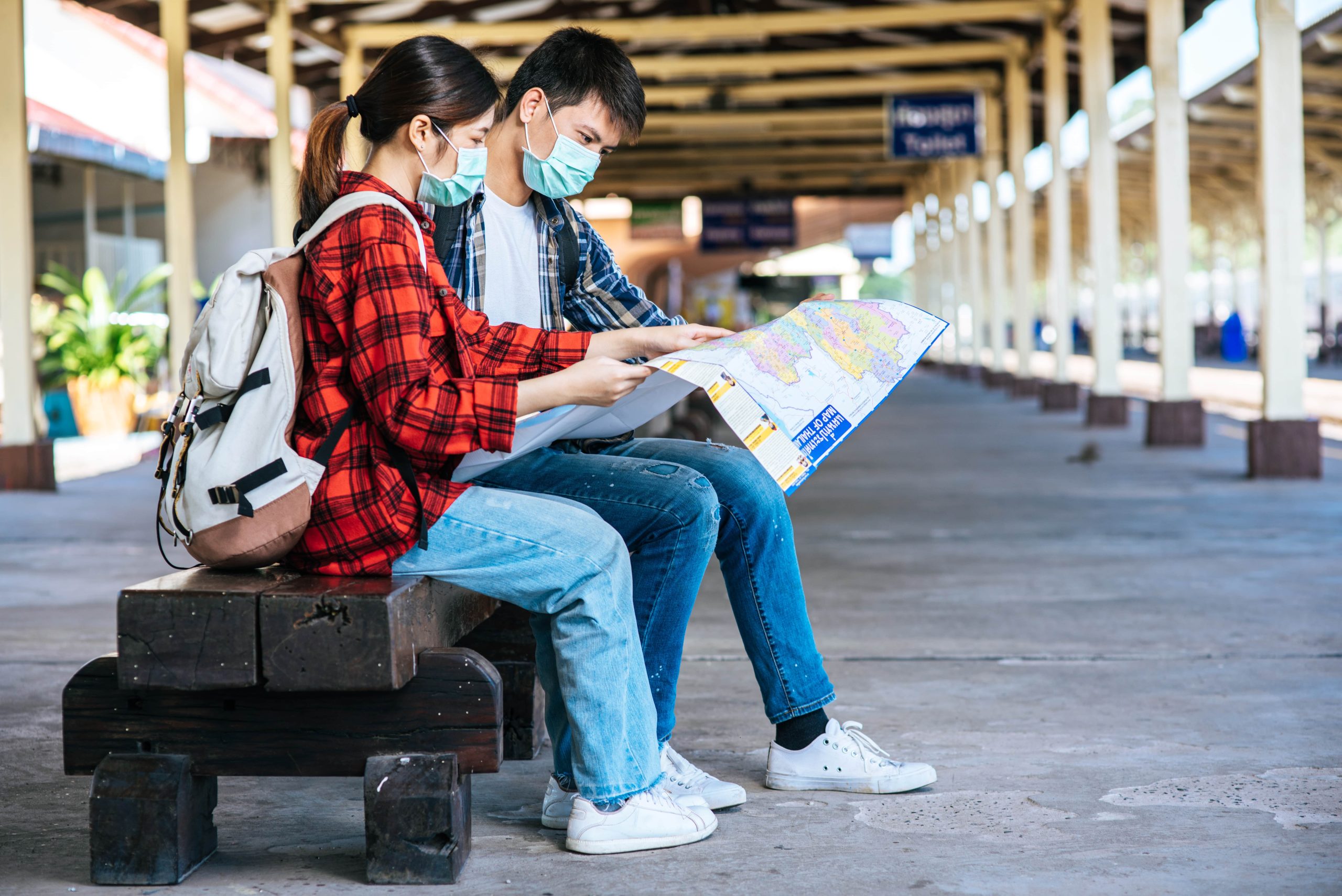 male-female-tourists-look-map-beside-railway-min