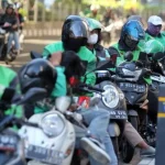 Ilustrasi para pengemudi ojek online (ojol) menunggu orderan di pinggir jalan. Pemerintah menetapkan kebijakan THR tunai bagi ojol dan kurir online, sesuai dengan Surat Edaran Kemnaker 2025 (Foto: ANTARA FOTO/Yulius Satria Wijaya)