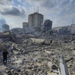 Ilustrasi warga Palestina berjalan di tengah puing-puing bangunan yang hancur akibat serangan udara Israel. (Foto: AP Photo/Hassan Eslaiah)