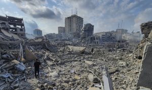 Ilustrasi warga Palestina berjalan di tengah puing-puing bangunan yang hancur akibat serangan udara Israel. (Foto: AP Photo/Hassan Eslaiah)