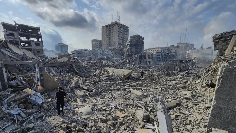 Ilustrasi warga Palestina berjalan di tengah puing-puing bangunan yang hancur akibat serangan udara Israel. (Foto: AP Photo/Hassan Eslaiah)