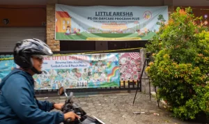 Warga melintas di dekat penitipan anak atau daycare Little Aresha yang disegel polisi di Umbulharjo, Yogyakarta, Minggu (26/4/2026). (Foto: Antara Foto/Andreas Fitri Atmoko Via BBC)