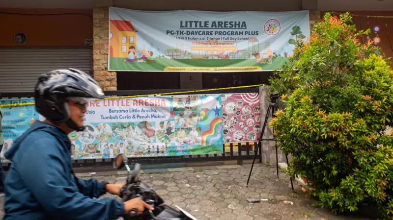 Warga melintas di dekat penitipan anak atau daycare Little Aresha yang disegel polisi di Umbulharjo, Yogyakarta, Minggu (26/4/2026). (Foto: Antara Foto/Andreas Fitri Atmoko Via BBC)