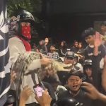 Seorang suporter membawa seekor buaya yang diikat ke tengah kerumunan saat nobar Derby Jawa Timur antara Persebaya Surabaya melawan Arema FC di Lapangan Kodikmar, Surabaya. (Foto: Screenshot TikTok @@alvinvin4973)